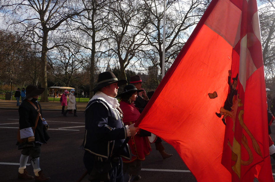 Des figurants portant un drapeau rouge au défilé