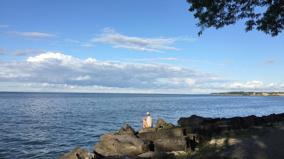 Un homme assis au bord du lac Ontario