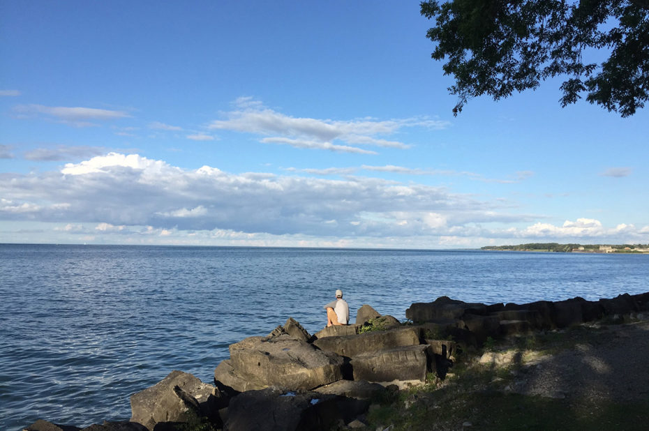 Un homme assis au bord du lac Ontario