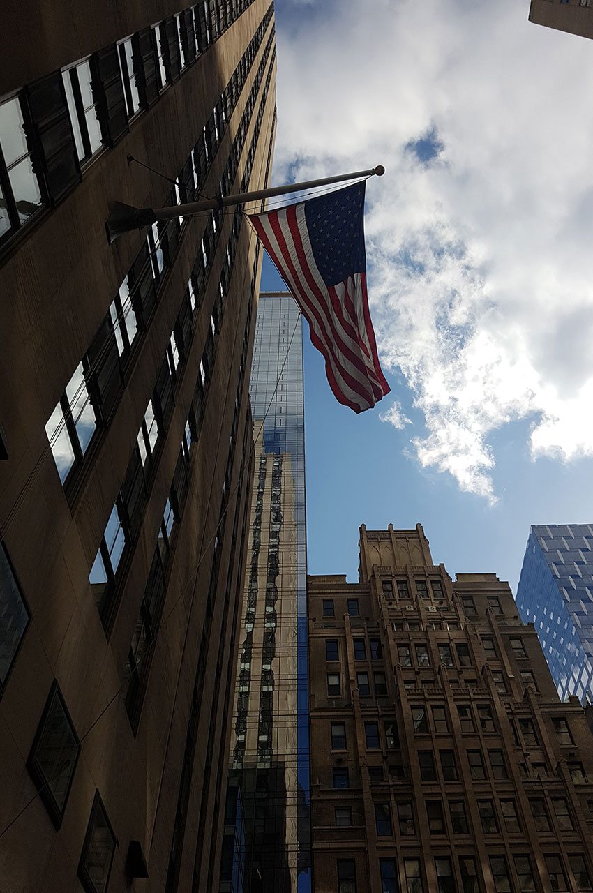 Drapeau américain entouré des tours du Rockefeller Center