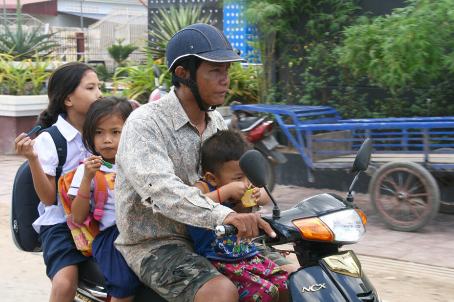 Un père et ses enfants sur une motocyclette