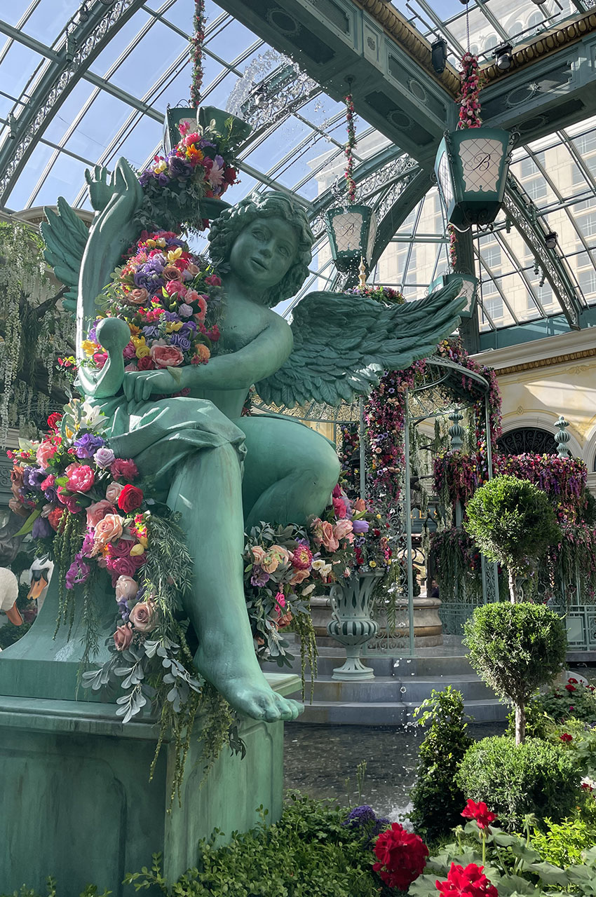 Statue d'ange entouré de fleurs multicolores