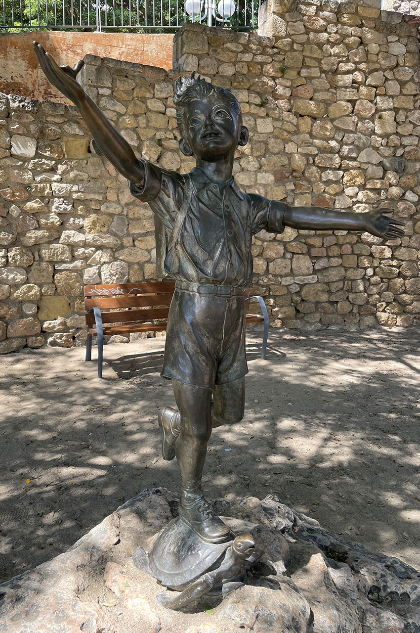 Statue en bronze d'un garçon debout sur une tortue