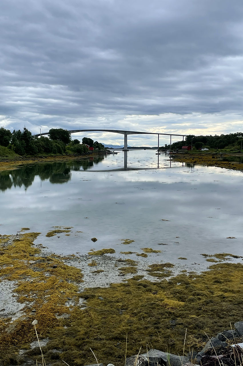 Le pont de Brønnøysund et les nuages se reflètent sur les eaux du fjord