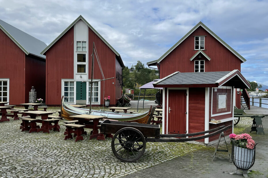 Sur la place du village, des barques et des charrettes sont exposées