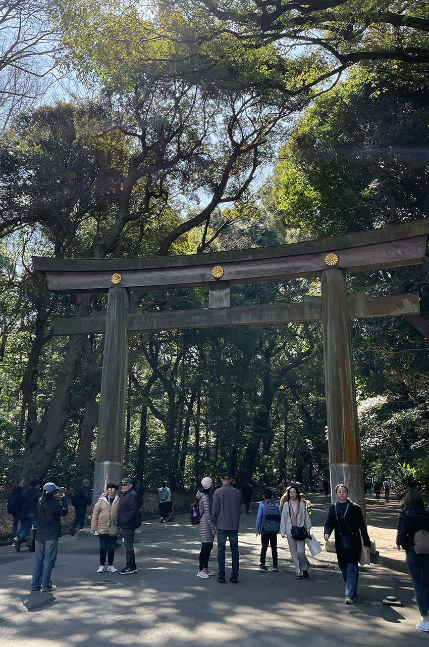 Les gens se prennent en photo sous le torii à l'entrée du parc Yoyogi