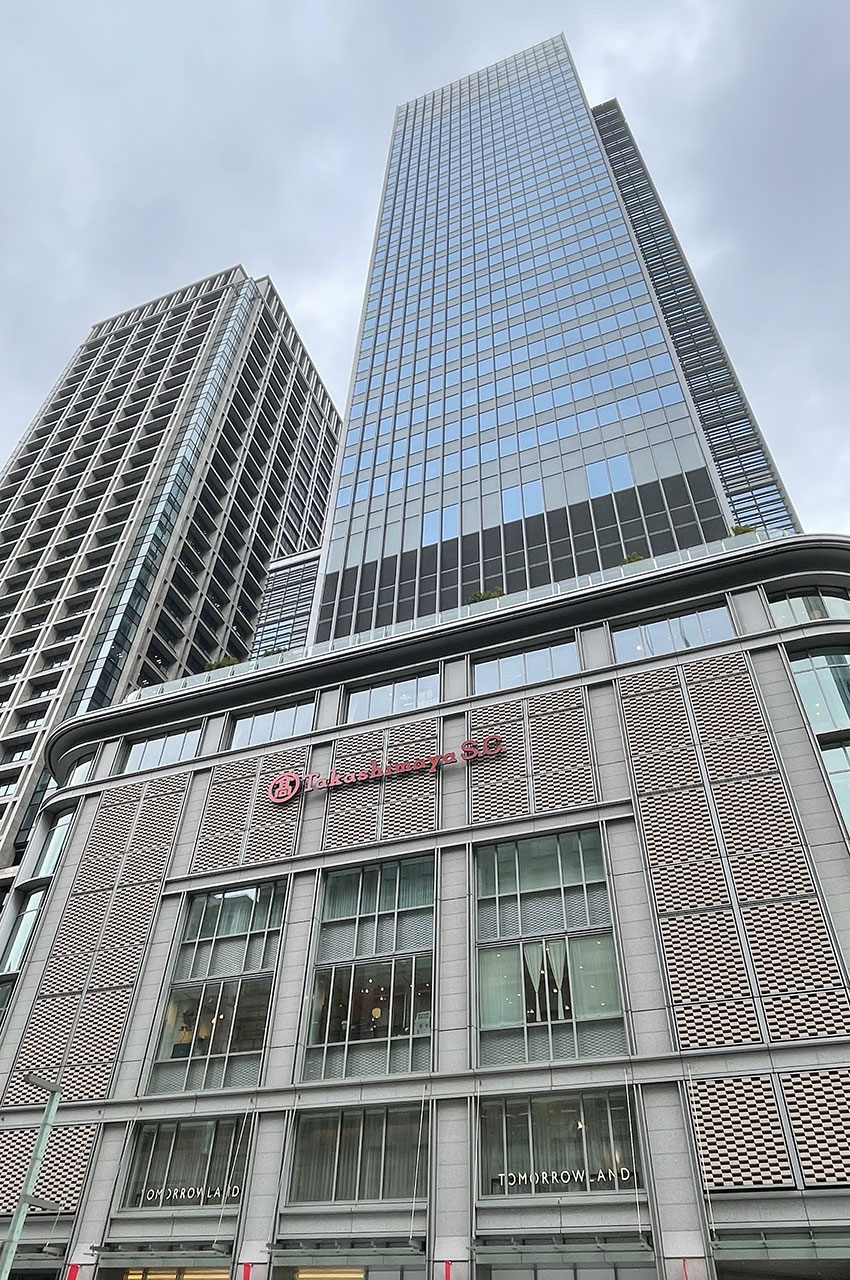 Un building de verre touche le ciel au-dessus du magasin Takashimaya